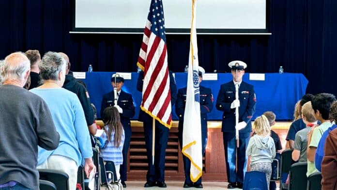 PXL_20241111_203831270~2 United States Coast Guard color guard in ceremonial uniform presenting the American flag, symbolizing patriotism and service