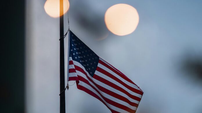 American Flag at dawn flying at half mast by Rocco Cappella