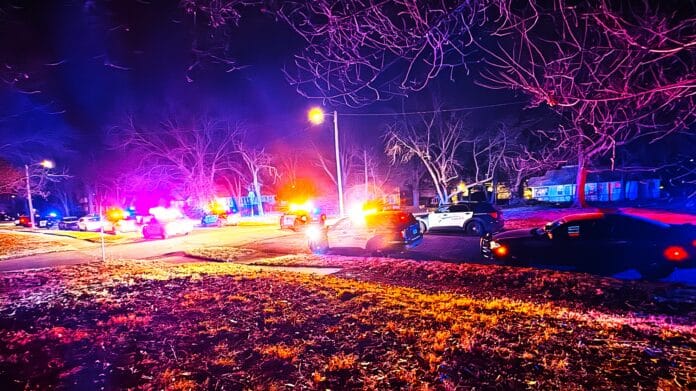 Police cars on a road at night in Central Topeka during standoff.