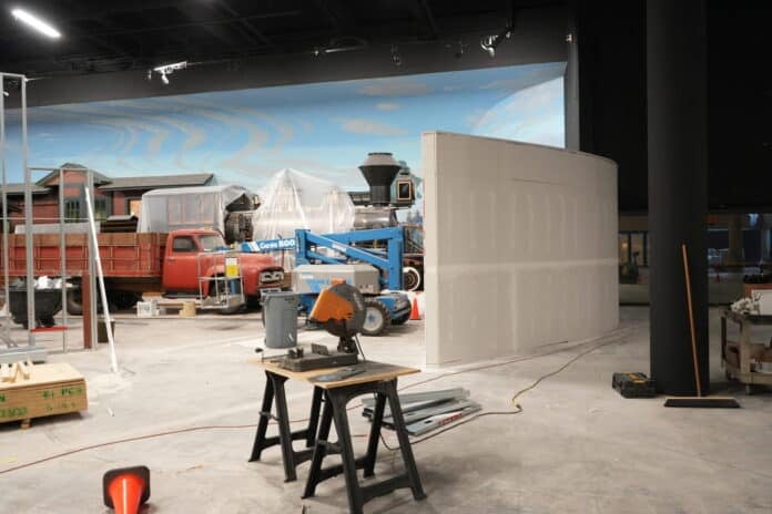 Vintage train engine and old truck displayed in Kansas Museum of History gallery amid new wall construction for fall reopening.