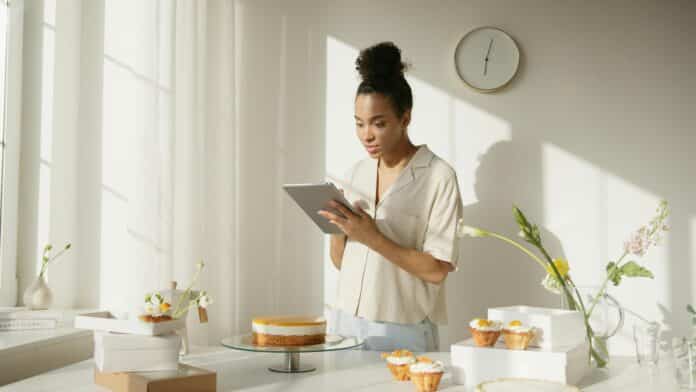 Female business owner using a silver ipad by Anna Nekrashevich