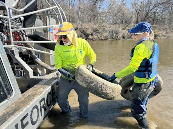 Friends of the Kaw volunteers David Sain and LlynnAnn Luellen haul tires to an airboat.