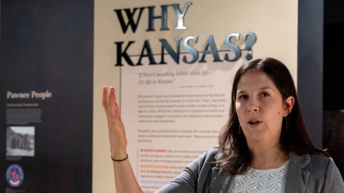 PB050360-2048x1152 Sarah Bell, director of the Kansas Museum of History, talks about the renovated gallery space during a Nov. 5, 2025, interview. The gallery asks visitors: What is Kansas? What was Kansas? and Why Kansas? (Photo by Sherman Smith/Kansas Reflector)