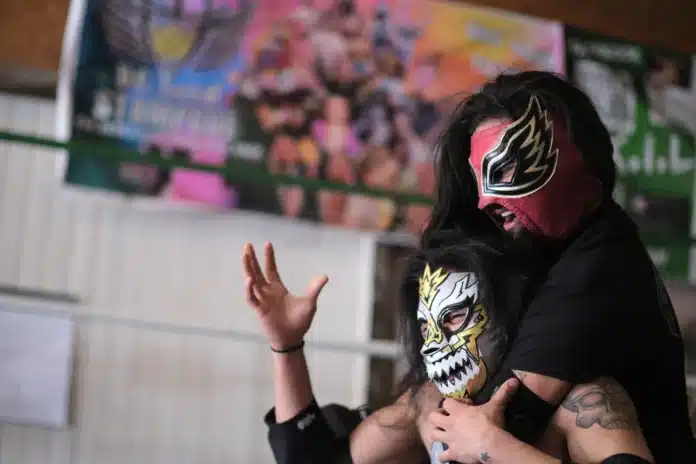 download (63) Calen Moore / Kansas News Service Angel De Paz (top) grapples with El Diablo (bottom) in the ring as they practice for their upcoming luchador performances.