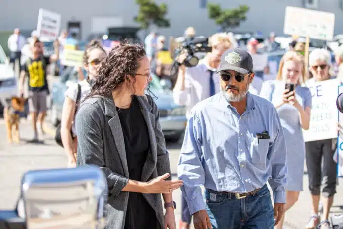 Zachary Ruth / KMUW Former Coldwater Mayor Joe Ceballos (right) and his attorney Sarah Balderas walk to the entrance of the Immigration and Customs Enforcement facility on May 13. Balderas told the media she intends to secure a bond for Ceballos.