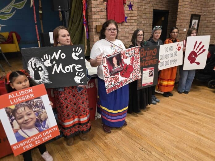 MMIWR-Frank-2048x1536-1 Friends and family members hold posters of missing and murdered Indigenous women and girls in Duluth, Minn., in February. A new report found American Indian and Alaska Native survivors of violence say reductions in federal funding have led to over 1,000 unmet requests for help. (Photo by Frank Zufall/Wisconsin Examiner)